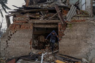 Mykola searchers for firewood in a building damaged by Russian military strikes in Pokrovsk